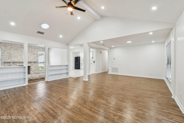 unfurnished living room featuring hardwood / wood-style flooring, a fireplace, visible vents, and beamed ceiling