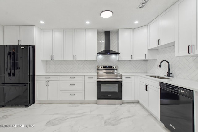 kitchen with marble finish floor, white cabinetry, a sink, wall chimney range hood, and black appliances