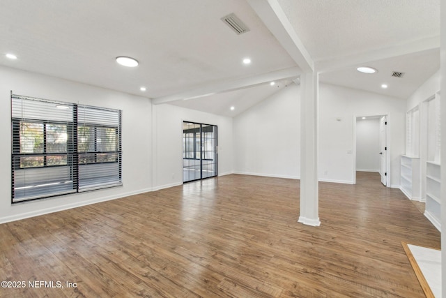 interior space with vaulted ceiling with beams, light wood-style floors, and baseboards