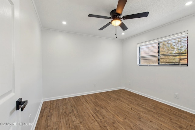 empty room with recessed lighting, a textured ceiling, baseboards, and wood finished floors