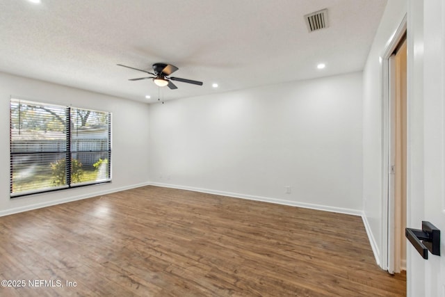 spare room with baseboards, visible vents, wood finished floors, and recessed lighting