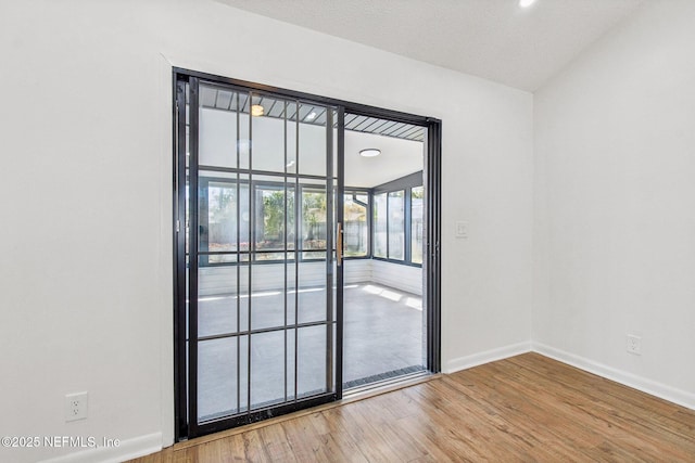 spare room featuring baseboards and wood finished floors