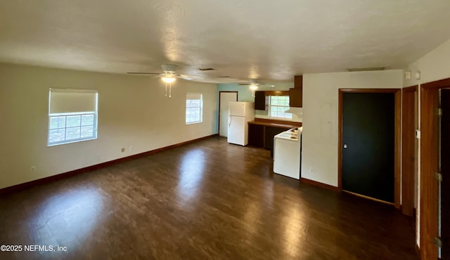 kitchen featuring freestanding refrigerator, dark wood finished floors, baseboards, and stove