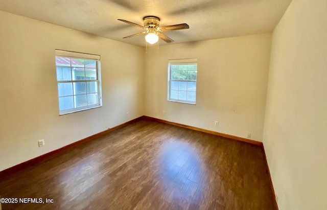 empty room featuring a ceiling fan, baseboards, and wood finished floors