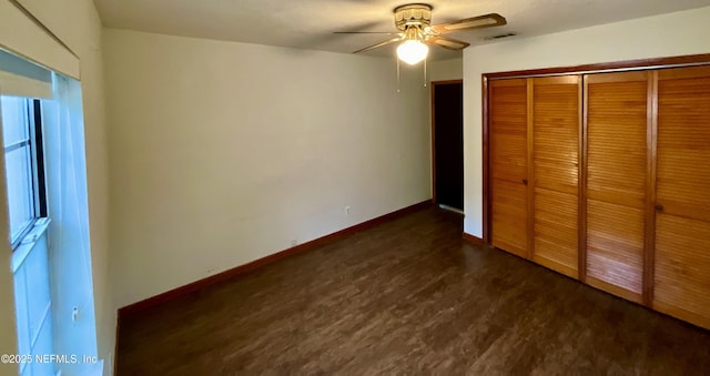 unfurnished bedroom with baseboards, visible vents, a ceiling fan, dark wood-type flooring, and a closet