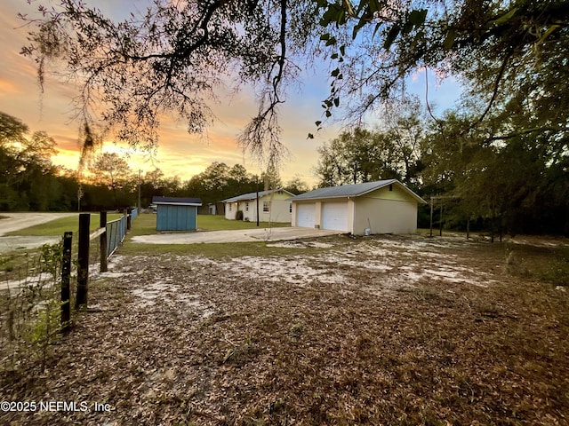 view of yard featuring an outbuilding, fence, and a garage