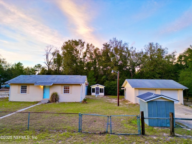 view of front facade featuring a front yard, fence private yard, a gate, and an outdoor structure