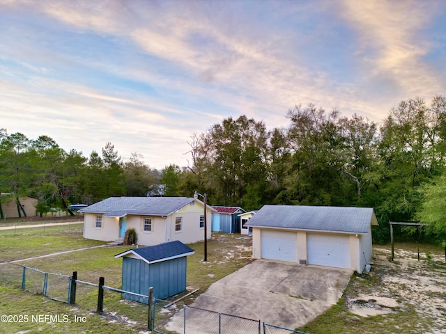 view of front of property with an outbuilding, a gate, fence, a garage, and a front lawn