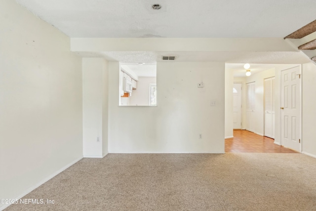 carpeted empty room with visible vents and baseboards