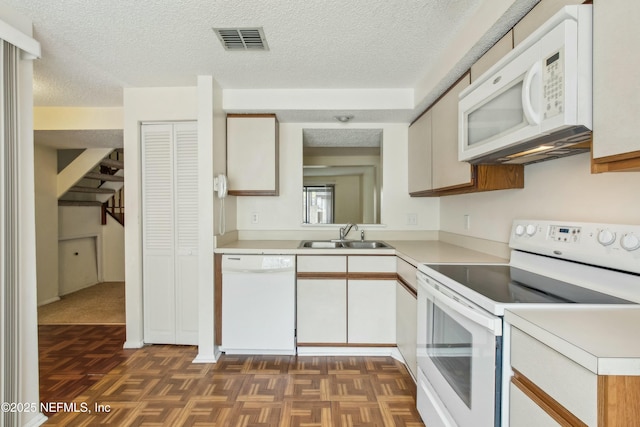 kitchen with white appliances, visible vents, light countertops, and a sink