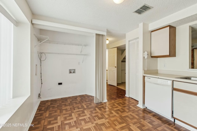 washroom with laundry area, baseboards, visible vents, a textured ceiling, and washer hookup