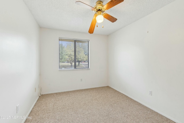 carpeted empty room with a textured ceiling, a ceiling fan, and baseboards