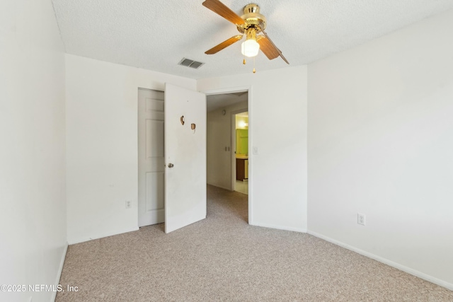 unfurnished bedroom featuring visible vents, carpet flooring, a textured ceiling, and baseboards