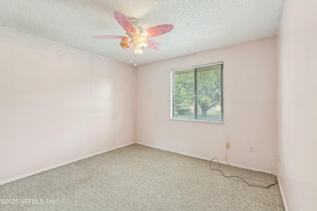 carpeted spare room featuring ceiling fan, baseboards, and a textured ceiling