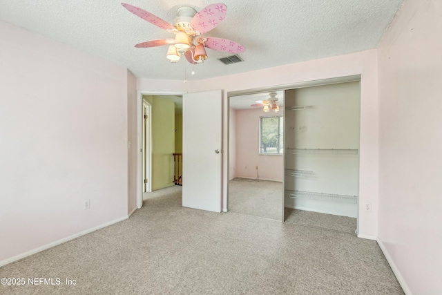 unfurnished bedroom featuring a closet, visible vents, ceiling fan, and a textured ceiling