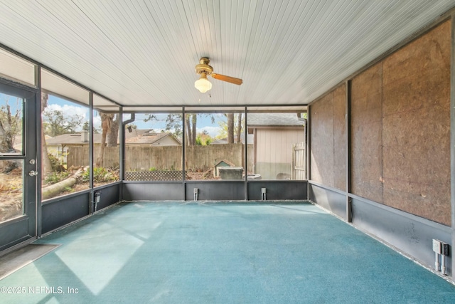 unfurnished sunroom featuring a ceiling fan