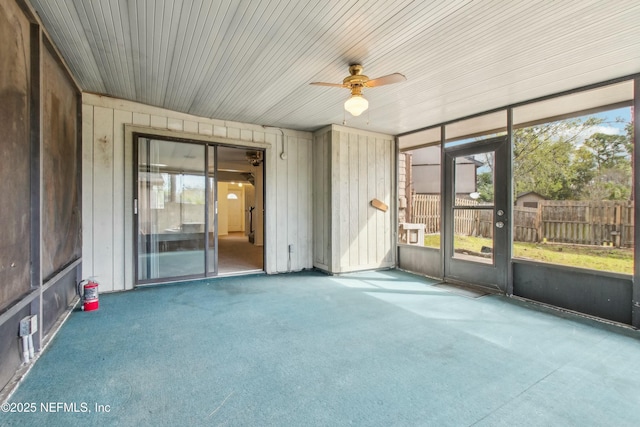 unfurnished sunroom featuring a ceiling fan