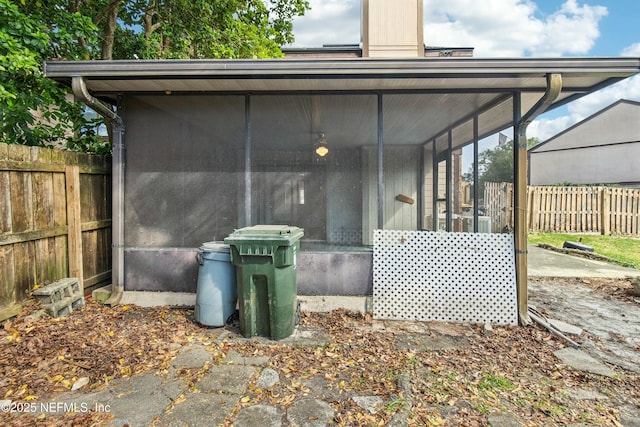 view of outbuilding with a sunroom and fence