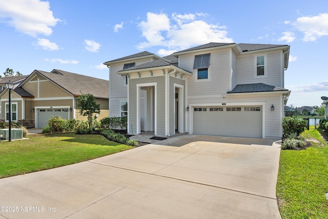 view of front facade with a front lawn, a garage, driveway, and a shingled roof