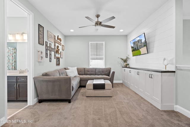 living room with recessed lighting, light colored carpet, a ceiling fan, and baseboards