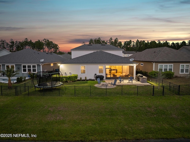 back of property with a fenced backyard, outdoor lounge area, a trampoline, a patio area, and a lawn