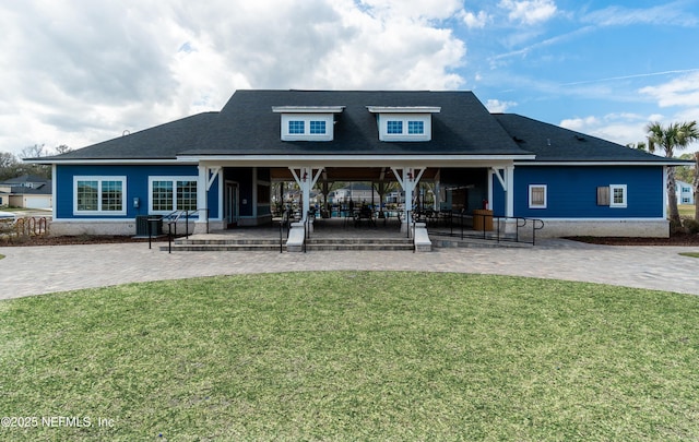 back of property featuring a shingled roof, central AC, a lawn, and a patio