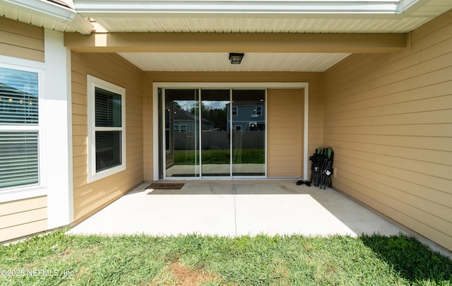 view of exterior entry with a patio area