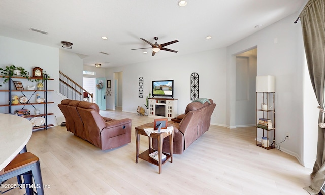 living area with recessed lighting, visible vents, stairway, and light wood finished floors