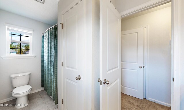 full bath featuring baseboards, tile patterned floors, toilet, and a shower with curtain