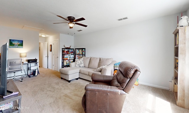 carpeted living room featuring attic access, visible vents, baseboards, and a ceiling fan