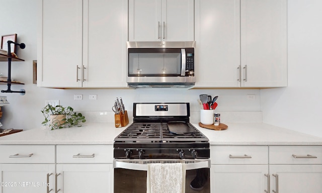 kitchen with white cabinets, stainless steel appliances, and light countertops