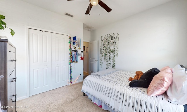 carpeted bedroom featuring a ceiling fan, a closet, visible vents, and baseboards