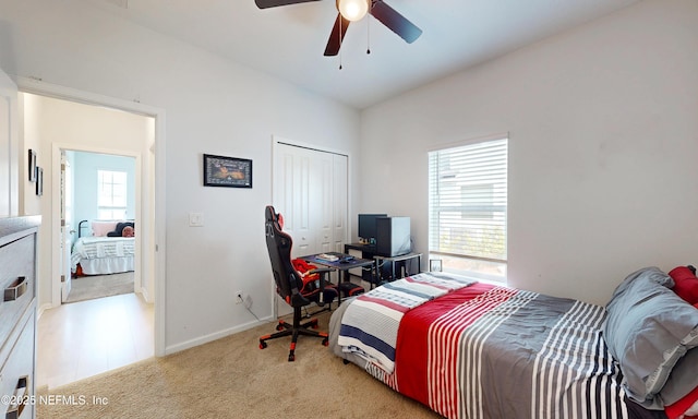 carpeted bedroom with a closet, ceiling fan, and baseboards