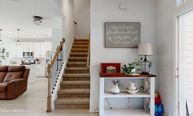 stairway with wood finished floors and recessed lighting