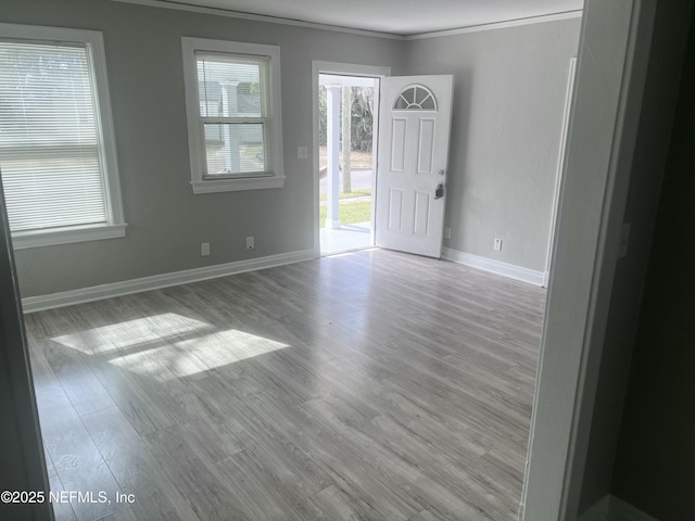 interior space with crown molding, wood finished floors, and baseboards