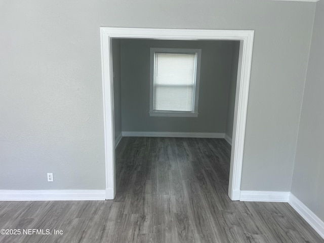 unfurnished room featuring baseboards and wood finished floors