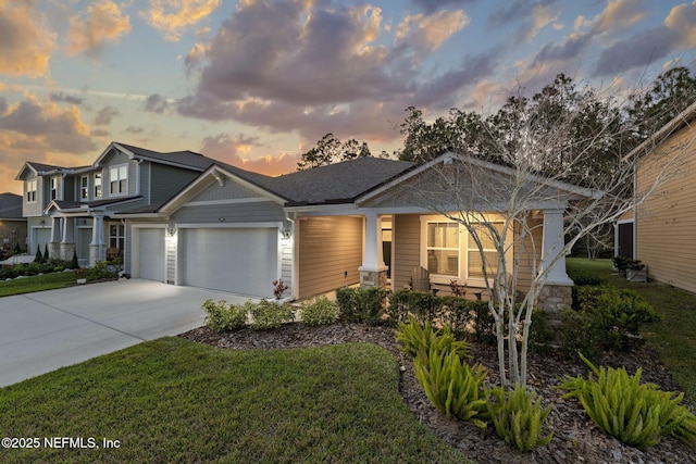 craftsman inspired home with a garage, concrete driveway, and a lawn