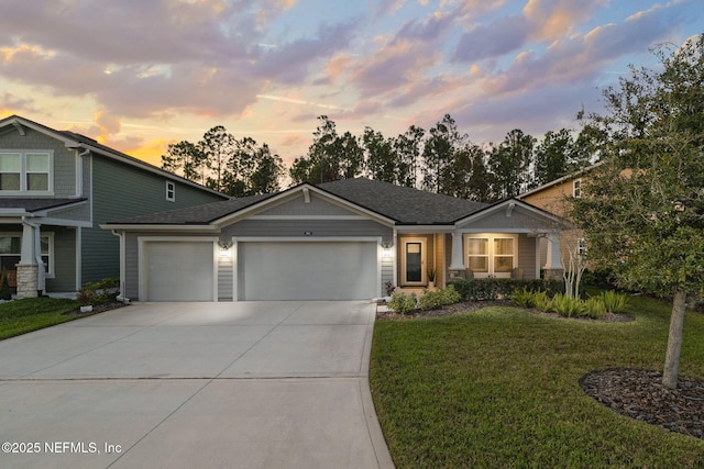 view of front of house featuring an attached garage, driveway, a front lawn, and roof with shingles