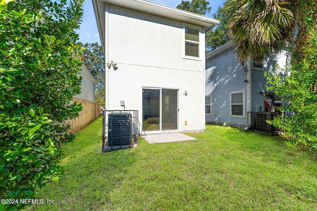 8120 Dandy Ave, Jacksonville, FL 32211 - back of house with central AC unit, stucco siding, fence, and a yard