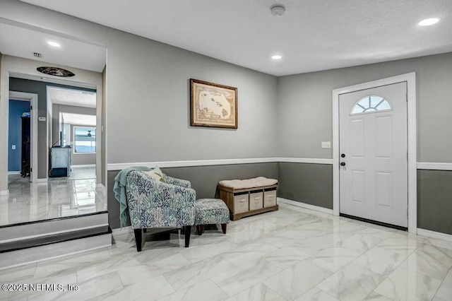 entryway featuring marble finish floor, baseboards, and recessed lighting