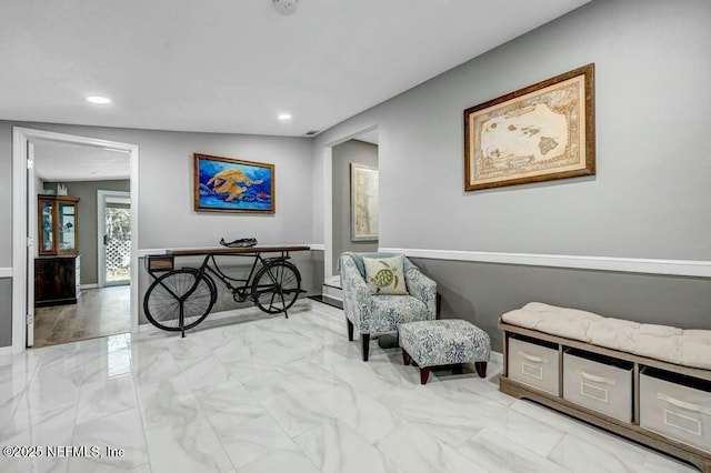 sitting room with baseboards, marble finish floor, and recessed lighting