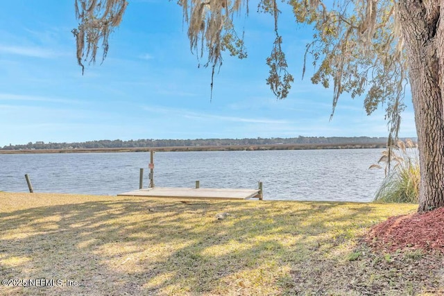 view of dock featuring a water view and a yard