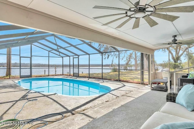 outdoor pool featuring a water view, a patio area, glass enclosure, and a ceiling fan