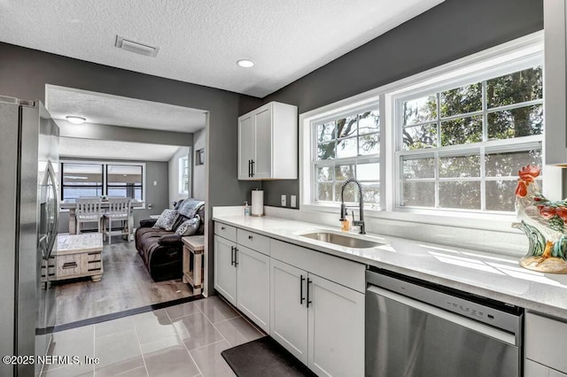 kitchen with stainless steel appliances, a wealth of natural light, visible vents, and a sink