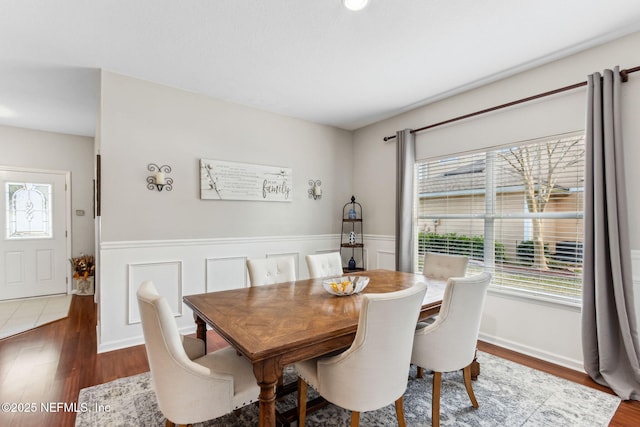 dining area featuring a wainscoted wall, wood finished floors, and a wealth of natural light