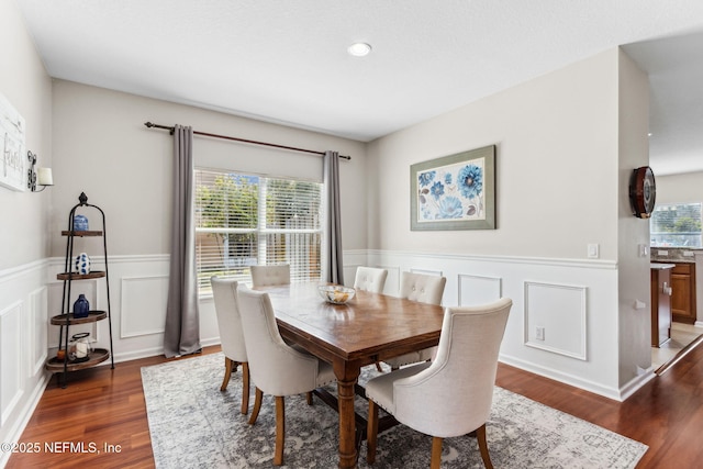 dining room featuring a wainscoted wall, plenty of natural light, and wood finished floors