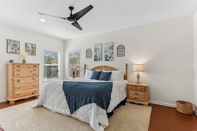 bedroom featuring ceiling fan, baseboards, and wood finished floors