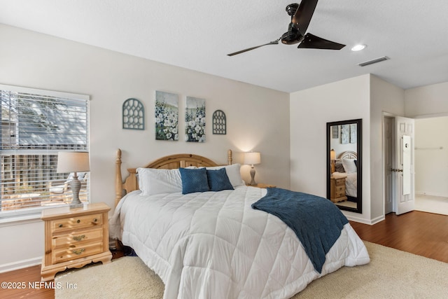 bedroom with visible vents, baseboards, and wood finished floors