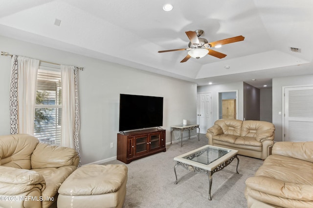 carpeted living area with a tray ceiling, recessed lighting, visible vents, a ceiling fan, and baseboards