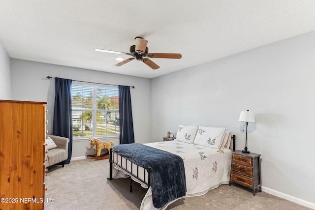 bedroom with a ceiling fan, light carpet, and baseboards